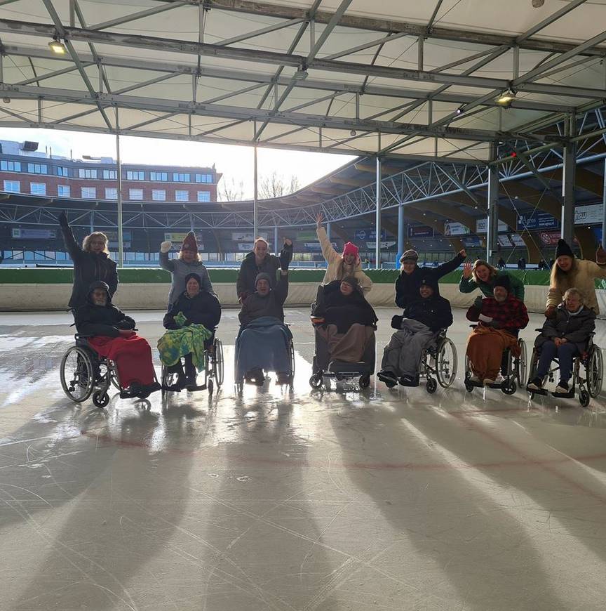 Rolstoelschaatsers met begeleiders op de ijsbaan van Haarlem