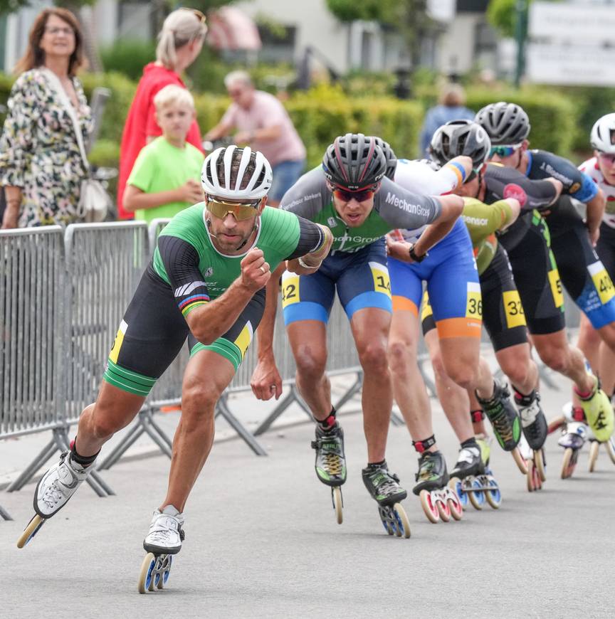 Crispijn Ariëns voert het peloton aan in Heerhugowaard, in de achtergrond kijkt zijn zoon toe.